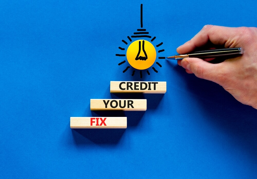 Fix Your Credit Symbol. Concept Words Fix Your Credit on Wooden Blocks on a Beautiful Blue Table Blue Background.